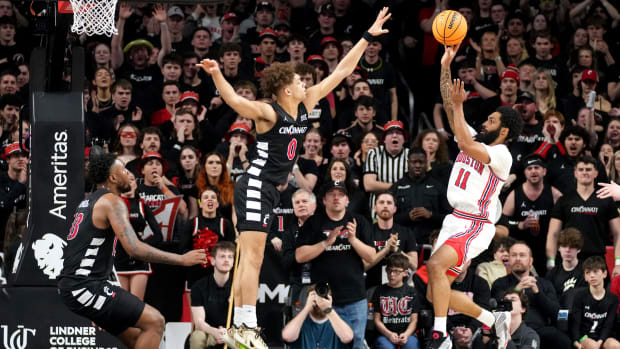 Houston Cougars guard Damian Dunn (11) rises for a shot as Cincinnati Bearcats guard Dan Skillings Jr. (0) defends in the first half of an NCAA college basketball game between the Houston Cougars and the Cincinnati Bearcats, Saturday, Feb. 10, 2024, at Fifth Third Arena in Cincinnati.